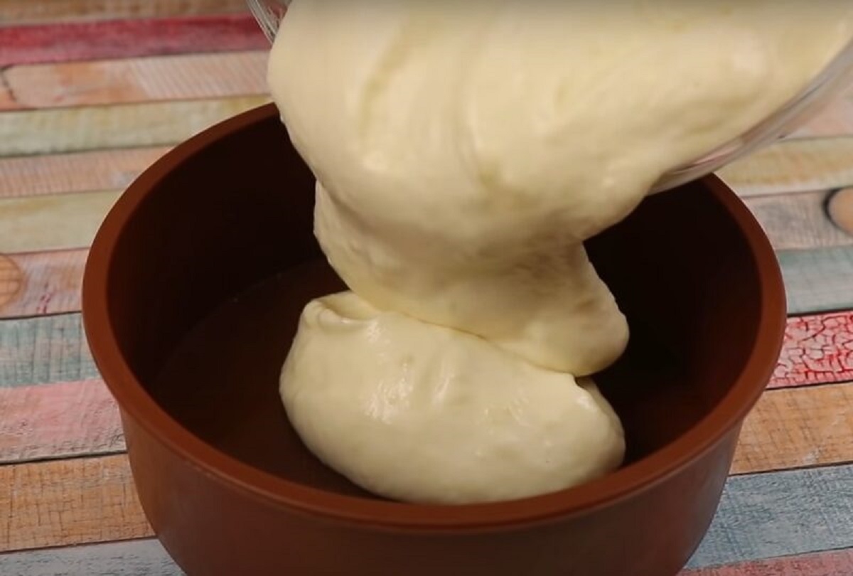 Jablečný mousse nandávání bílé směsi do hnědé formy 