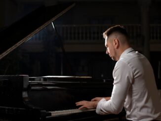 muž hraje na koncertní piano