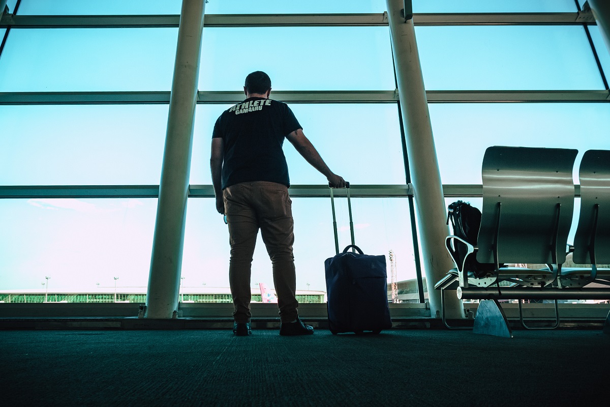 muž s kufrem na letišti