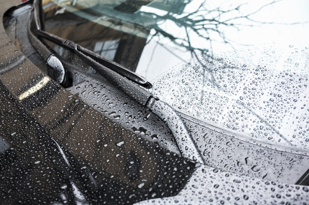Black,Car,Hood,Fragment,And,Windshield,Wipers,With,Raindrops,On