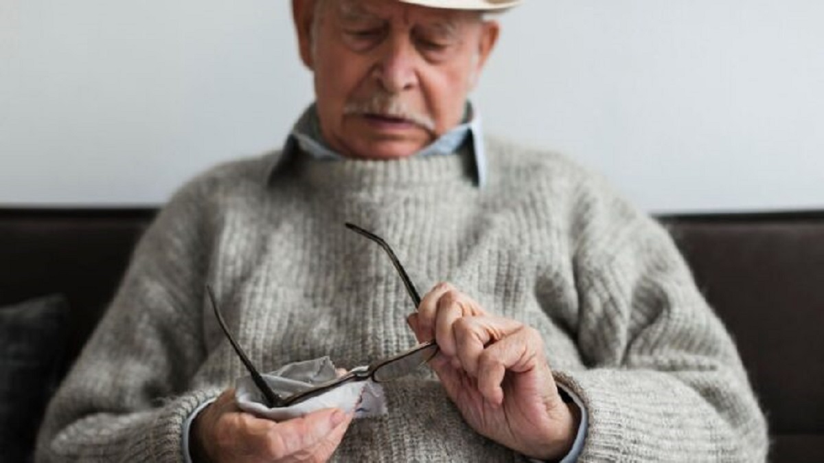 starý muž čistí brýle