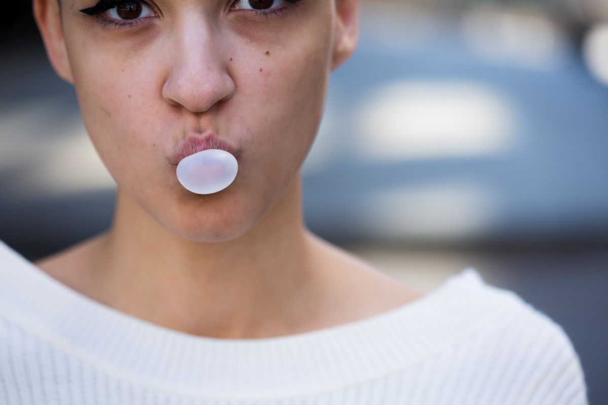 žena dělá bublinu ze žvýkačky